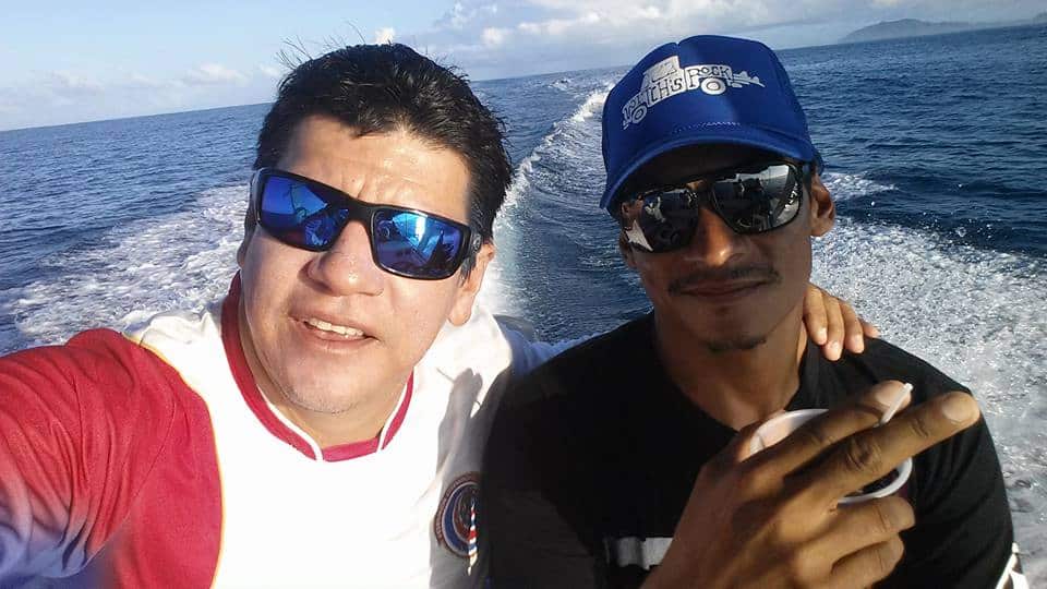 Two Witchs Rock Surf Camp employees on a boat, ocean backdrop.